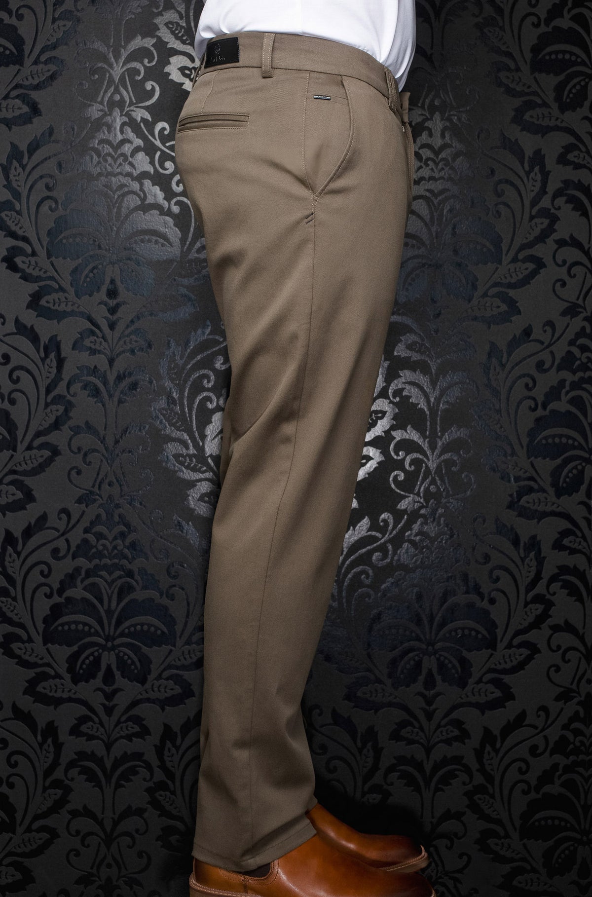 Pantalon chino taupe avec passants, poche passepoilée et petite étiquette logo pour homme par Au Noir, vue de côté arrière
