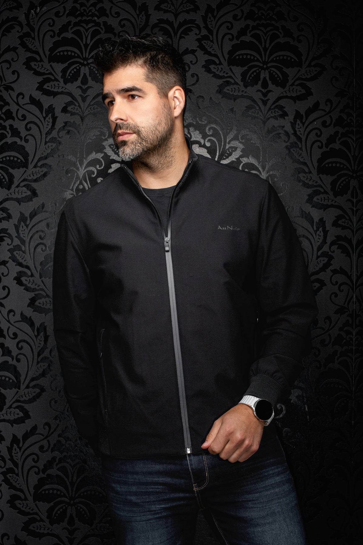 Vue de face d’un coupe-vent mi-saison style bomber bomber noire fermée avec col et poignets côtelés pour homme par Au Noir