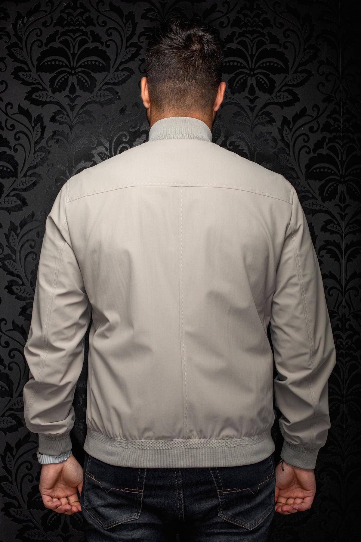 Sur mannequin de dos, le coupe-vent mi-saison style bomber gris pour homme par Au Noir