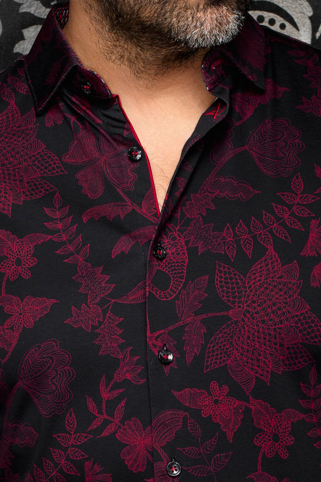 Au Noir men's black button-up shirt collar, red trim, glossy buttons and burgundy floral print, close-up