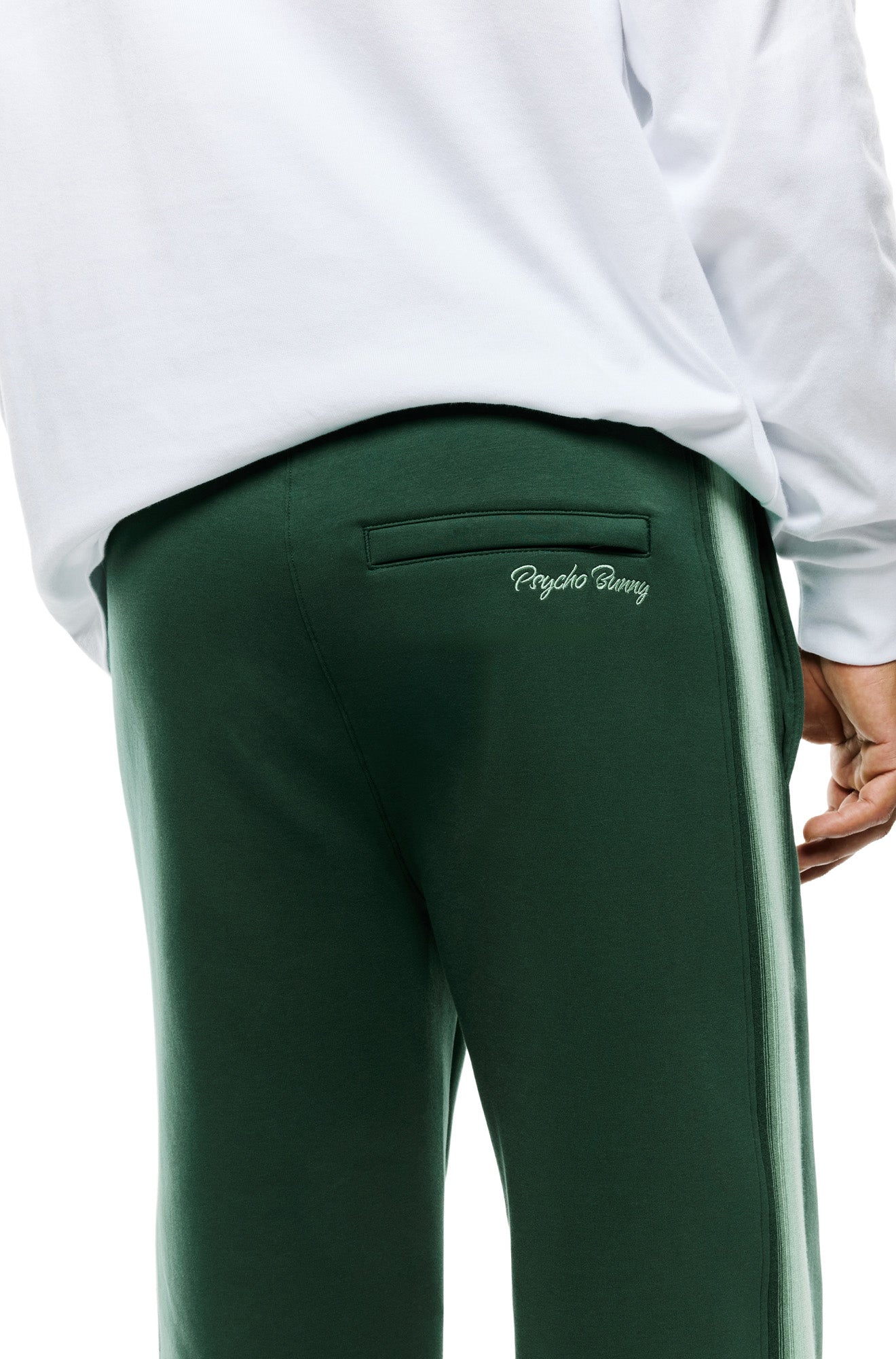 Psycho Bunny men's back detail of dark green sweatpants with welt pocket, embroidered text, and light green side stripe