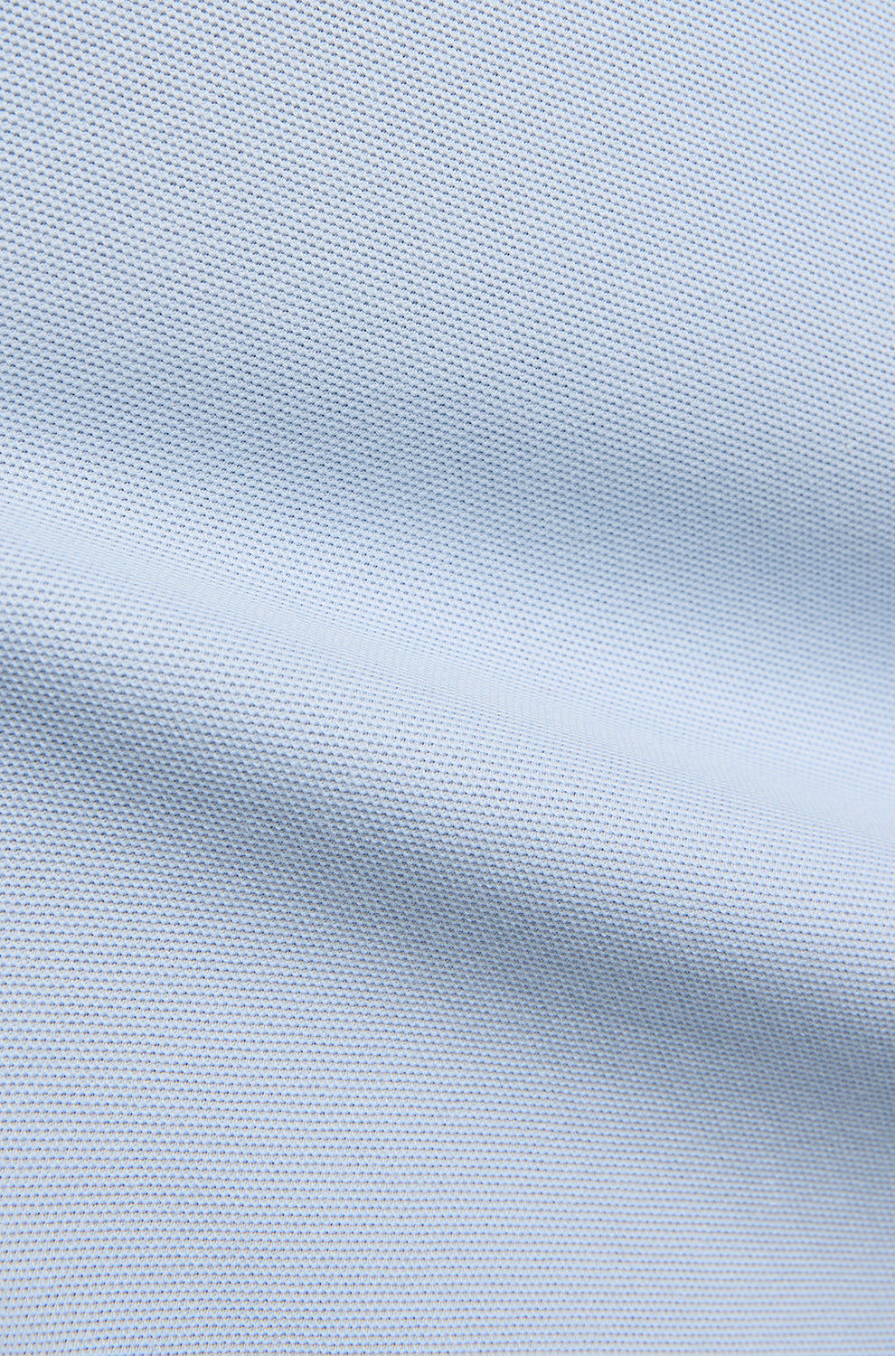 Tissu piqué bleu pâle montrant la texture fine et une couture horizontale pour homme par Psycho Bunny, en gros plan