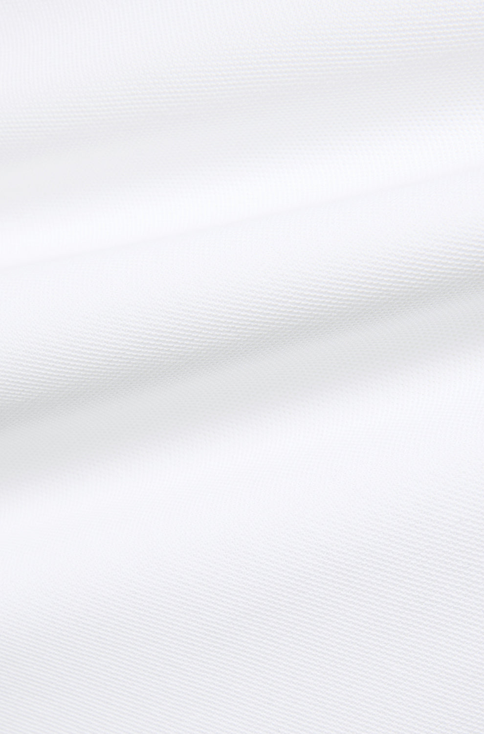 Gros plan du tissu piqué blanc texturé avec plis doux pour homme par Psycho Bunny