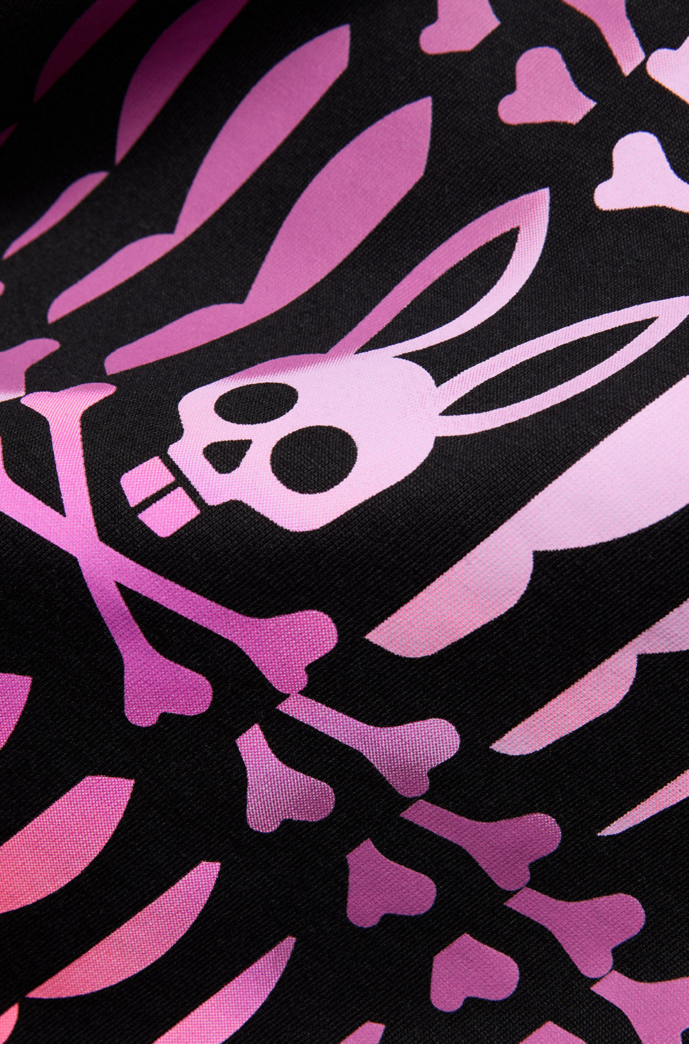 T-Shirt rose avec graphique Psycho Bunny, crâne et os sur le tissu noir du T-Shirt pour homme, en gros plan