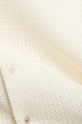 Tissu texturé crème du polo, avec patte boutonnée et point rose pour homme par Psycho Bunny, en gros plan