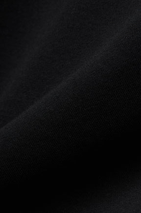 Tissu en maille noire du chandail manches longues pour homme par Psycho Bunny, en gros plan