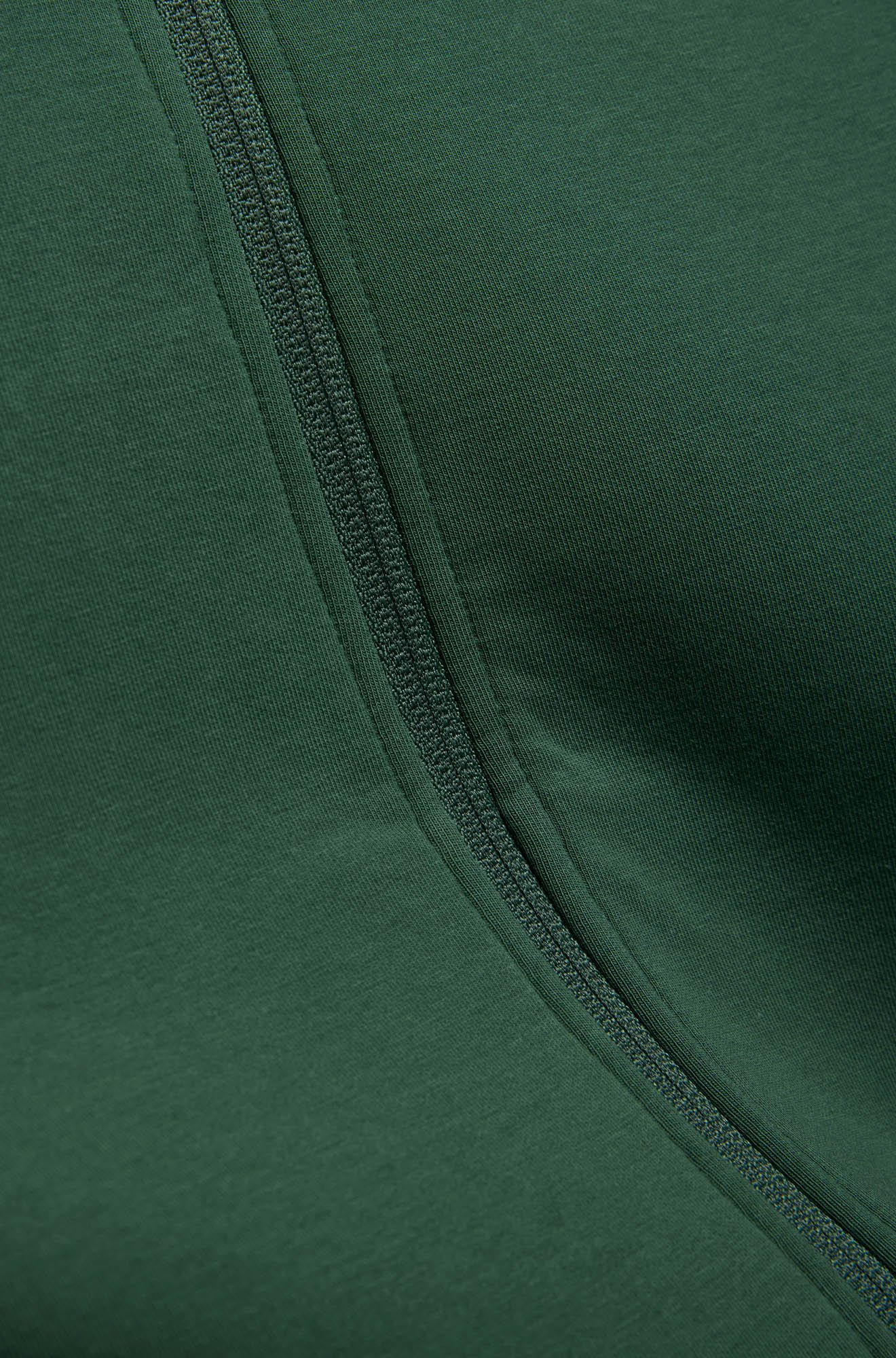 Men's close detail of dark green knit fabric and matching zipper tape on the jacket front by Psycho Bunny