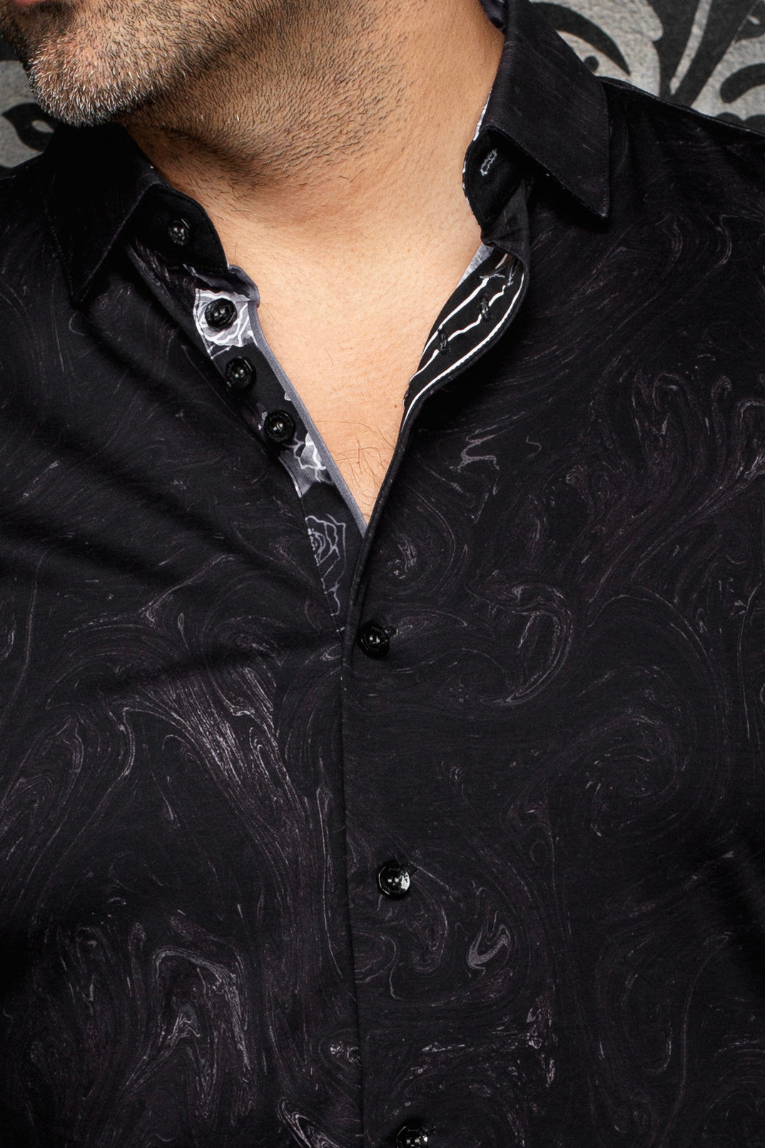 Gros plan du col de chemise noire à motif cachemire avec blanc et patte intérieure gris pour homme par Au Noir