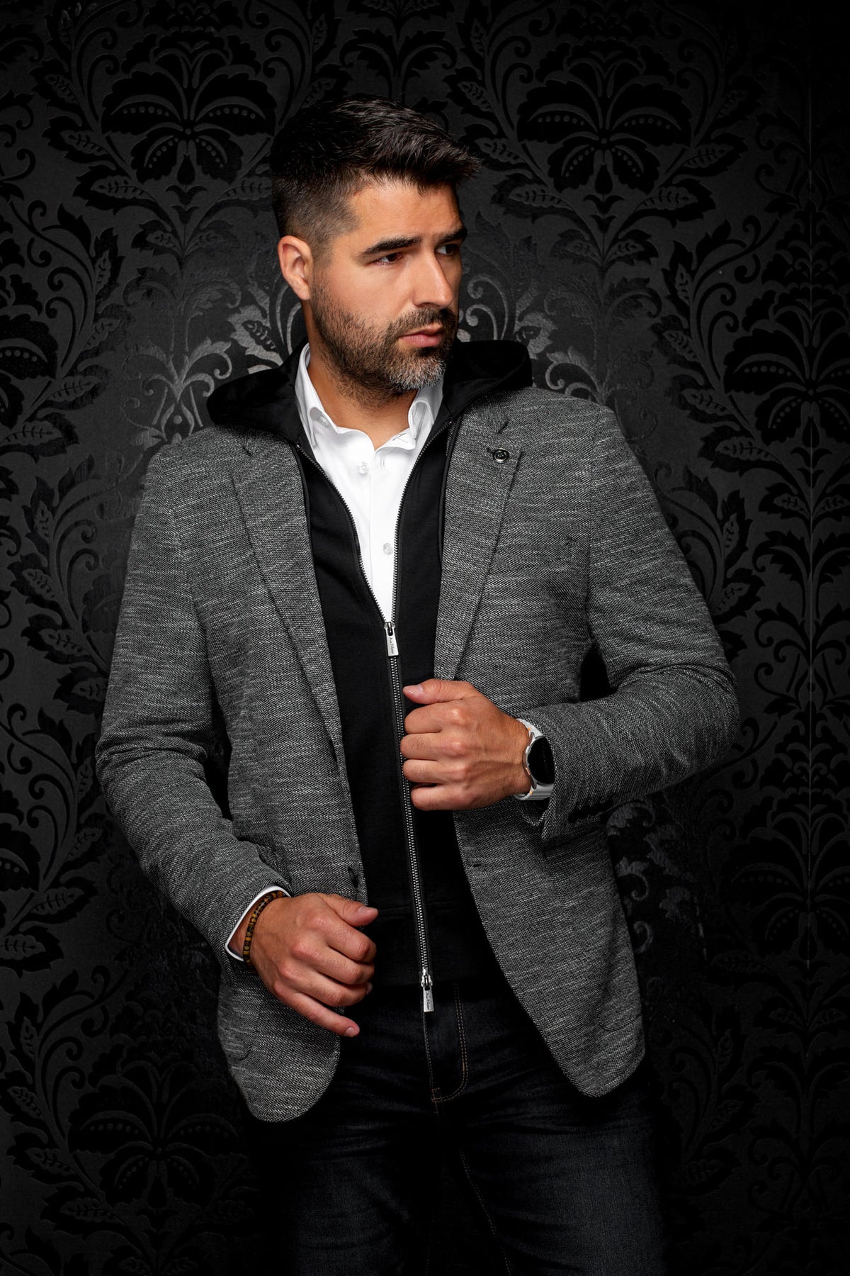 Vue de face d’un veston gris texturé avec revers crantés et insert noir à capuchon zippé pour homme par Au Noir