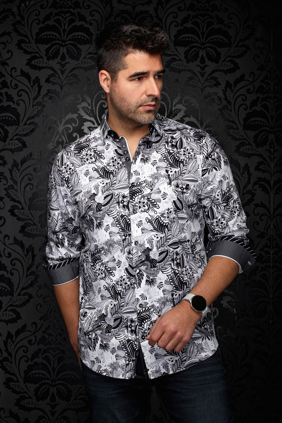 Sur mannequin de face, la chemise blanche à imprimé floral noir et gris, poignets roulés pour homme par Au Noir
