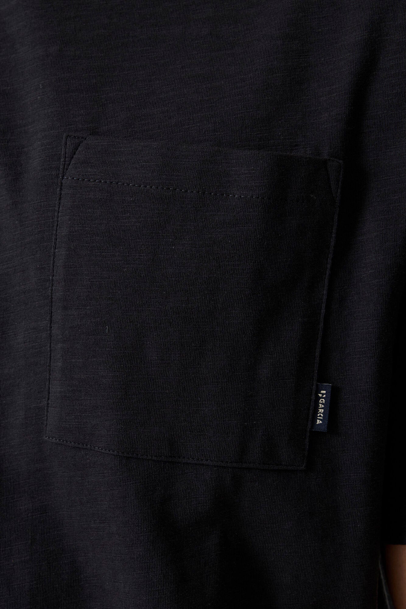 Poche poitrine du T-Shirt noir avec étiquette Garcia et texture tricotée pour homme, en gros plan