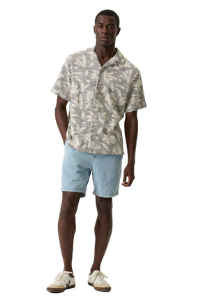 Vue de face plein pied d’une chemise crème à manches courtes et motif tropical noir pour homme par Garcia