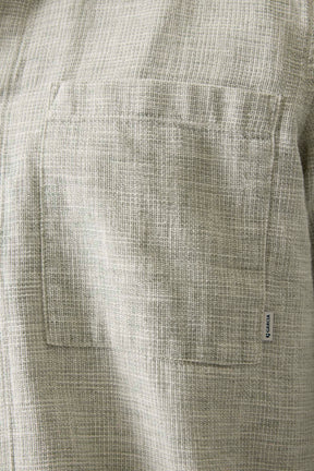 Détail d’une poche poitrine sur surchemise beige texturée avec petite étiquette logo pour homme par Garcia