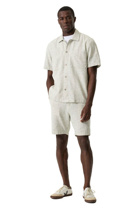 Vue avant légèrement de biais de la short jambe droite beige pâle texturée avec ourlets droits au genou pour homme