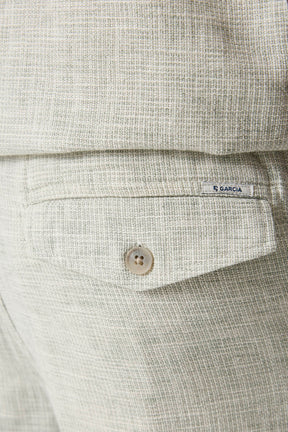 Short jambe droite beige pâle texturée avec poche arrière à rabat, bouton et petite étiquette Garcia, en gros plan