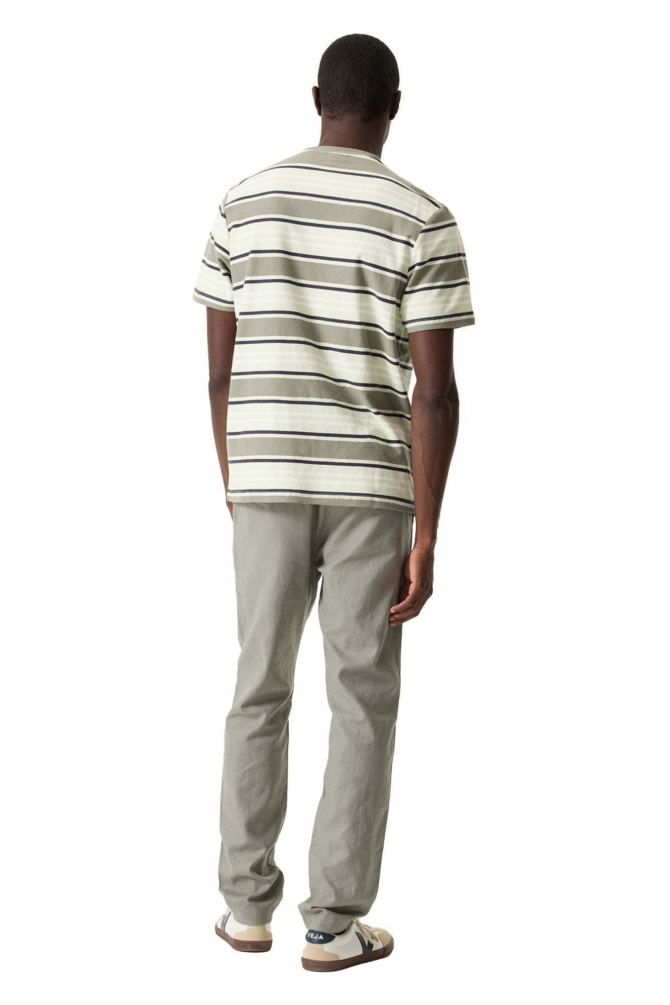 Vue arrière sur mannequin du pantalon droit olive pâle, taille partiellement couverte par un T-Shirt rayé pour homme
