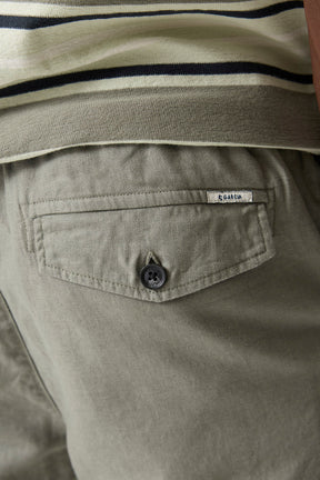 Gros plan sur la poche arrière à rabat du pantalon olive pâle avec bouton noir et étiquette Garcia pour homme
