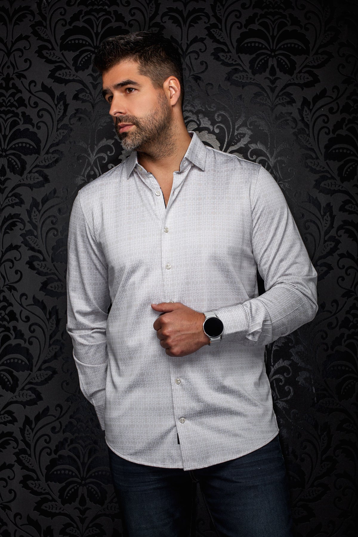 Sur mannequin de face, la chemise boutonnée gris pâle à motif avec col pointu et boutons blancs pour homme par Au Noir