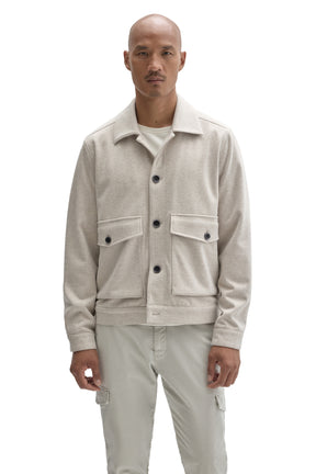 Front view of men's cream textured button-front jacket with spread collar and flap patch pockets by Robert Barakett