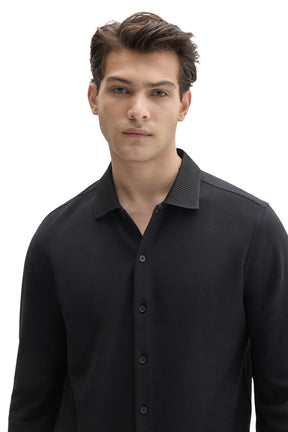 Men's close front view of black knit long-sleeve shirt with ribbed collar and tonal button front by Robert Barakett