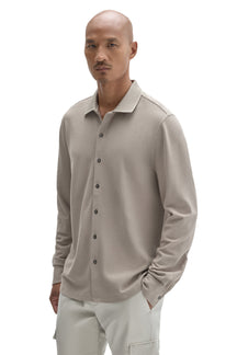 Men's front angled view of a light taupe long sleeve knit button-front shirt with ribbed collar by Robert Barakett