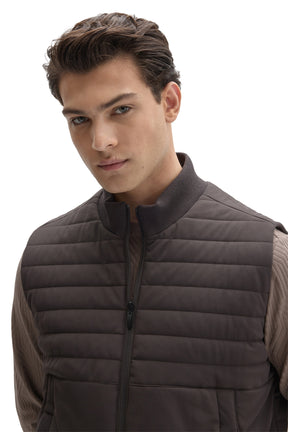 Men's close front view of dark taupe quilted vest with ribbed stand collar and zipper by Robert Barakett