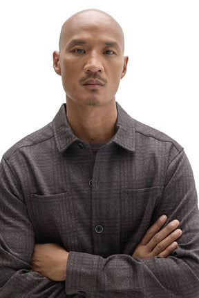 Men's close detail of charcoal plaid overshirt with point collar, chest pockets, and dark buttons by Robert Barakett