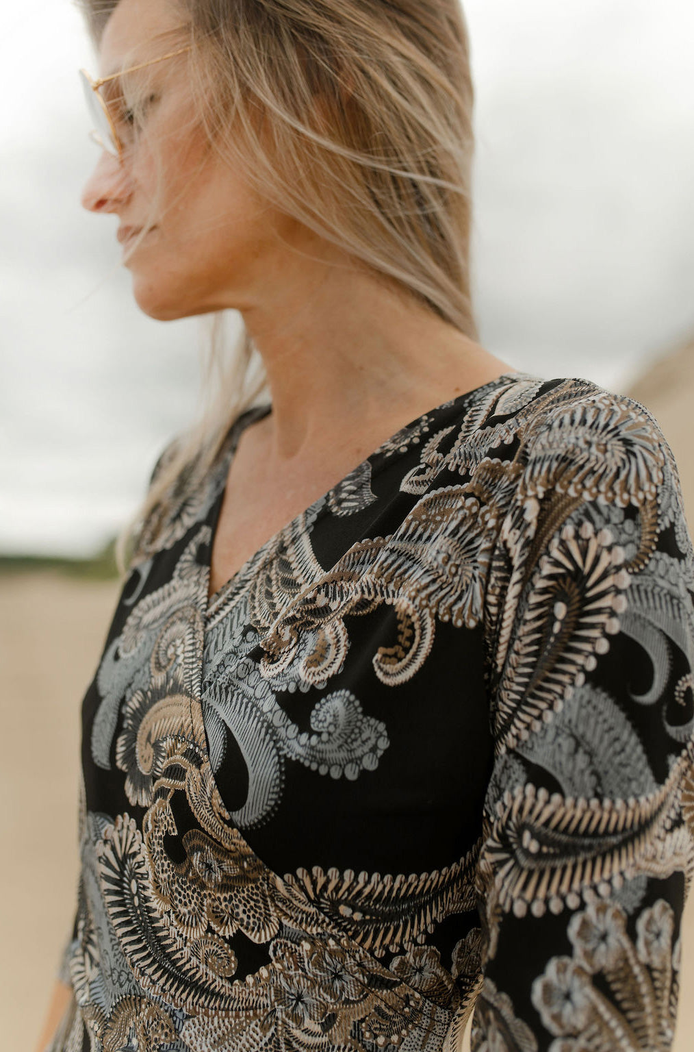 Rien ne se perd, tout se crée women's close detail of black paisley dress with beige, gray print and V-neckline