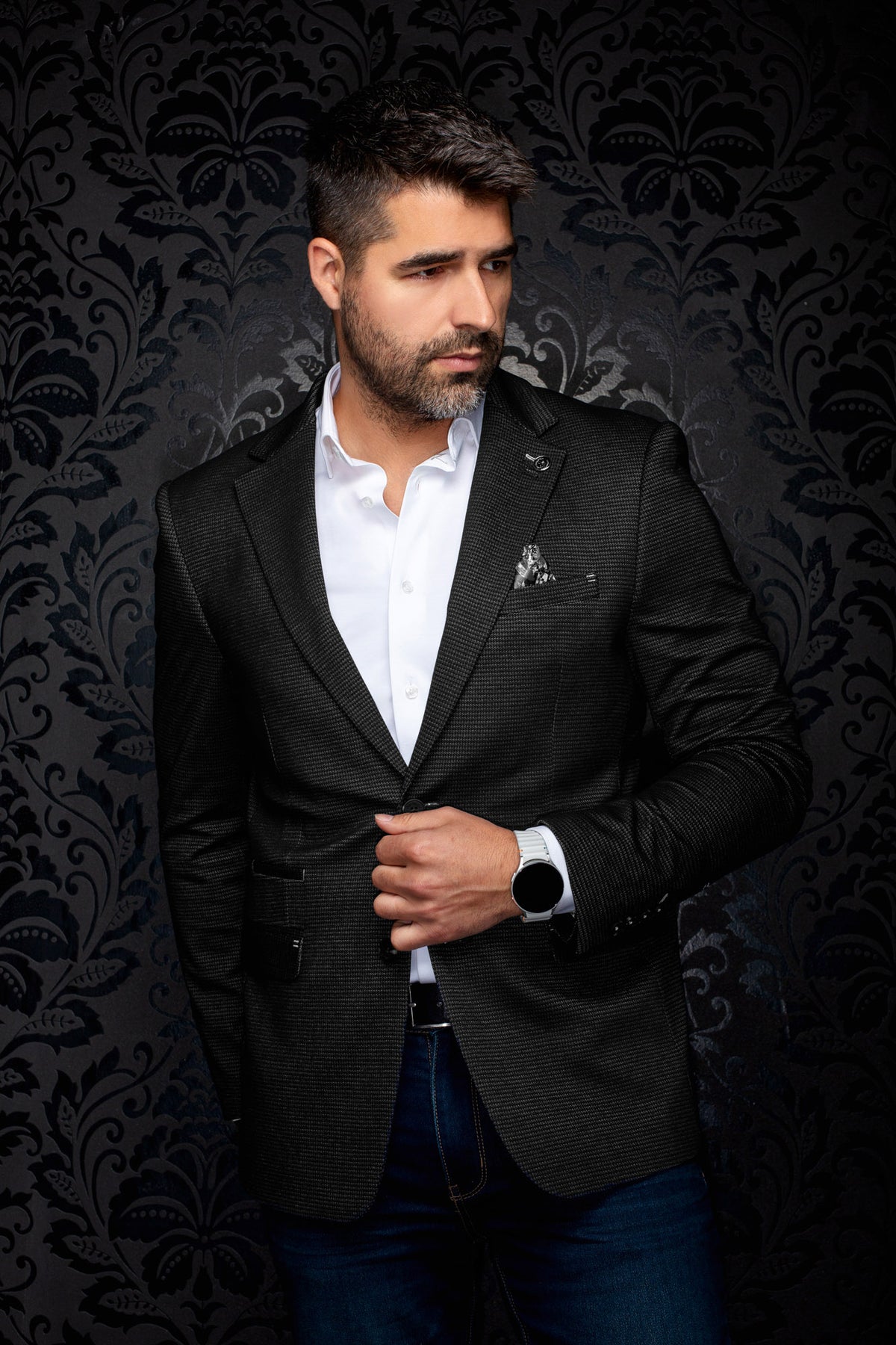 Veston noir texturé vu de face sur modèle avec pochette de poitrine et revers crantés pour homme par Au Noir