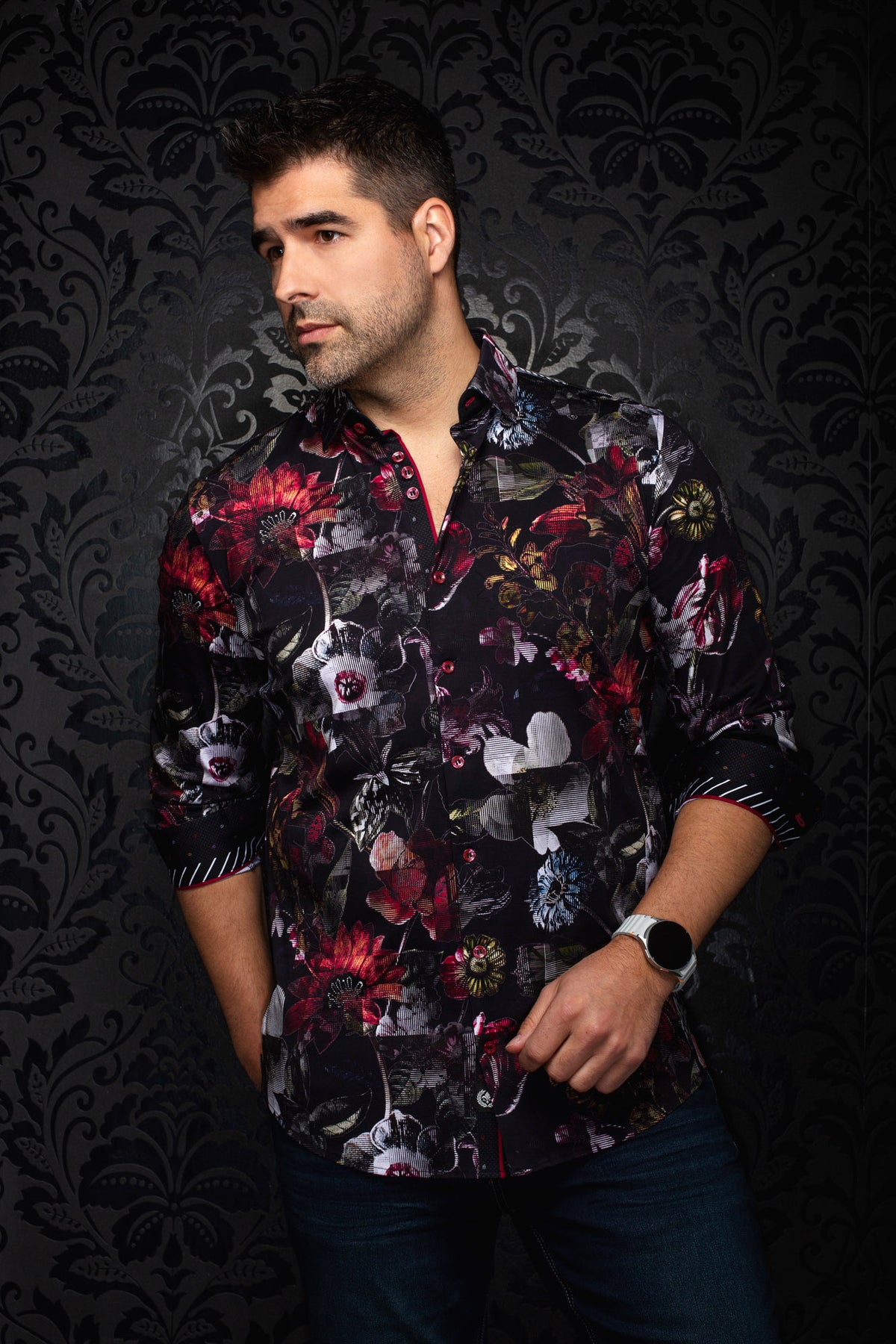 Vue de face d'une chemise noire fleurie avec poignets contrastants, manches roulées et boutons rouges pour homme par Au Noir