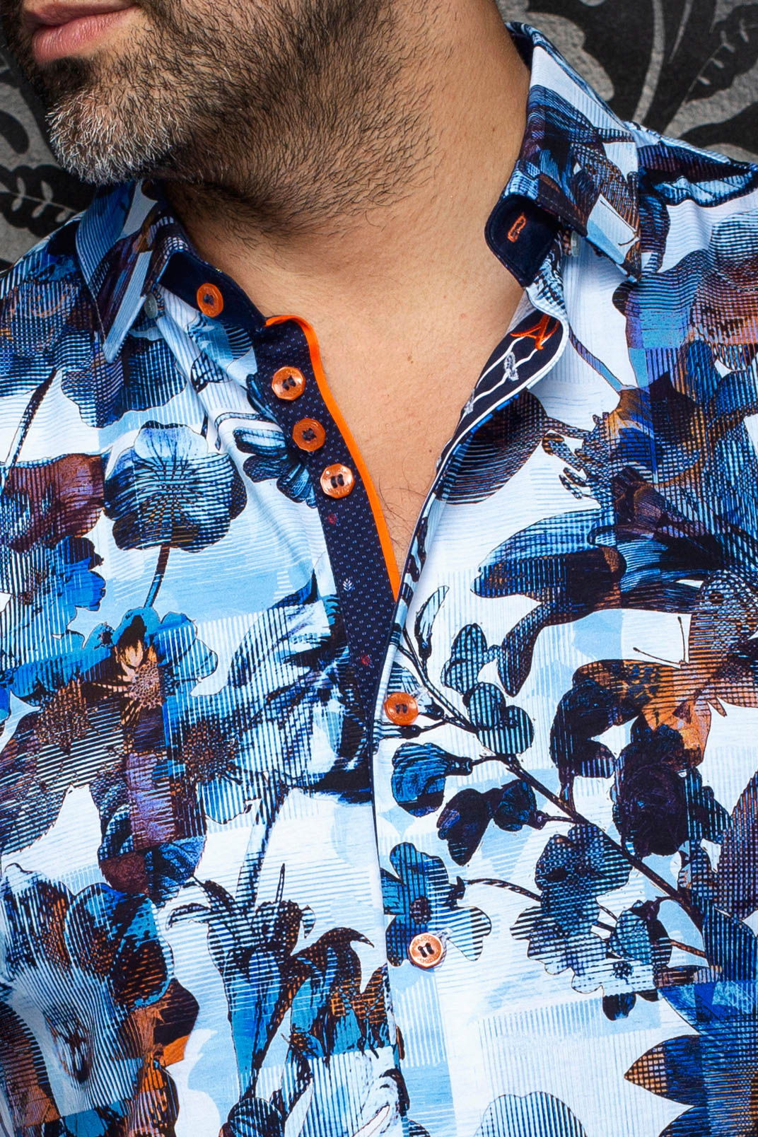 Col de la chemise bleue pâle fleurie, patte marine, boutons et bordure orange pour homme par Au Noir, en gros plan