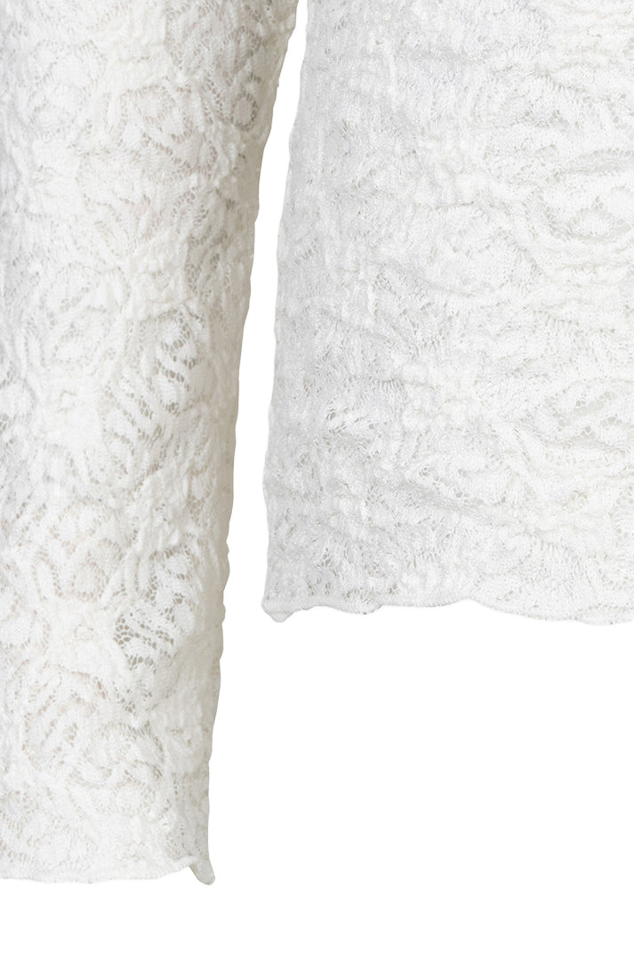 Women's close-up detail of the white floral lace sleeve and scalloped hem edge on the long-sleeve blouse by Esqualo