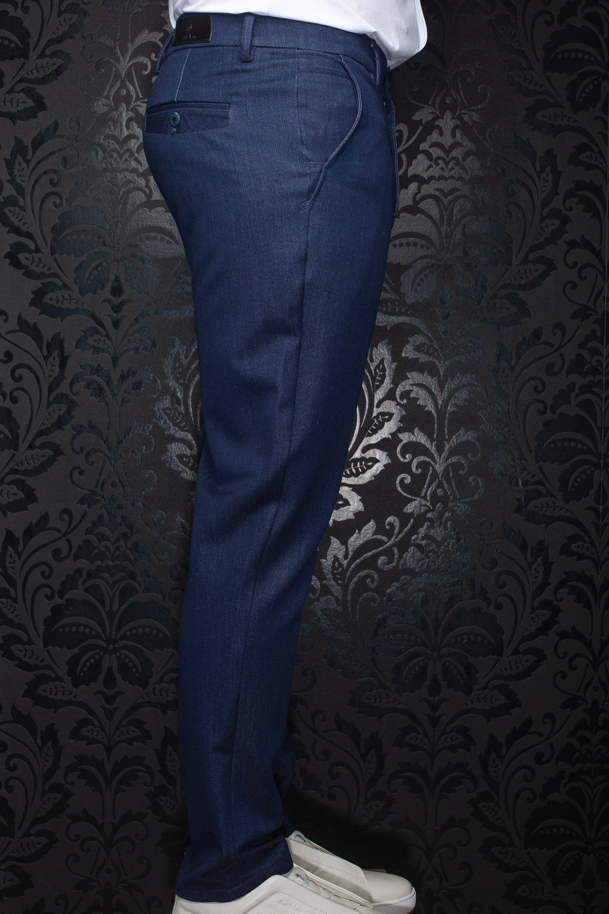 Vue de côté d’un pantalon bleu marine avec léger lustre tissé, poche passepoilée et passants pour homme par Au Noir