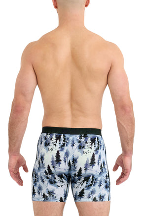 Vue arrière sur modèle du sous-vêtement bleu à imprimé forêt avec taille noire et ourlets droits pour homme par Saxx