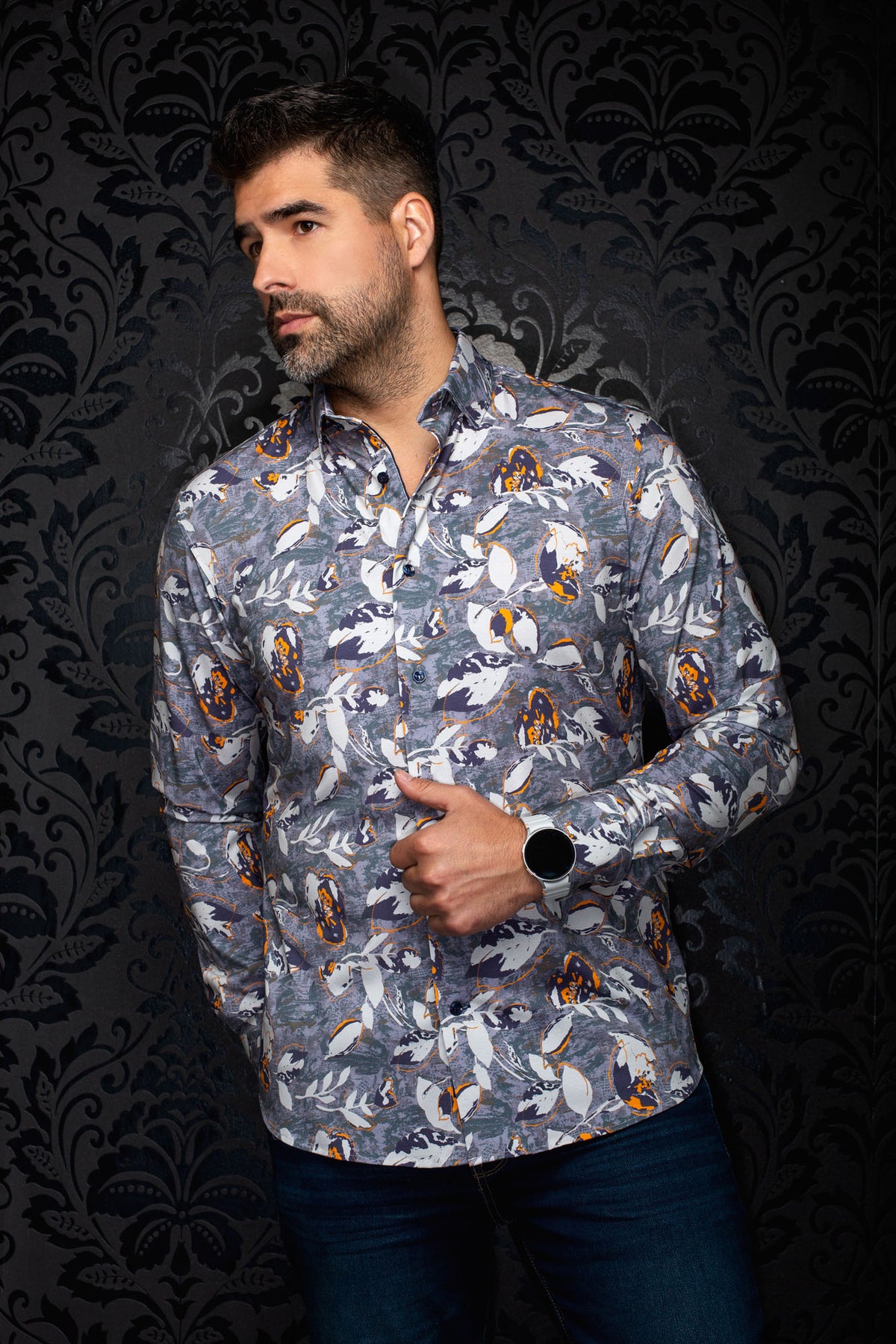 Sur mannequin de face, la chemise grise à imprimé floral blanc, accents orange et boutons foncés pour homme par Au Noir