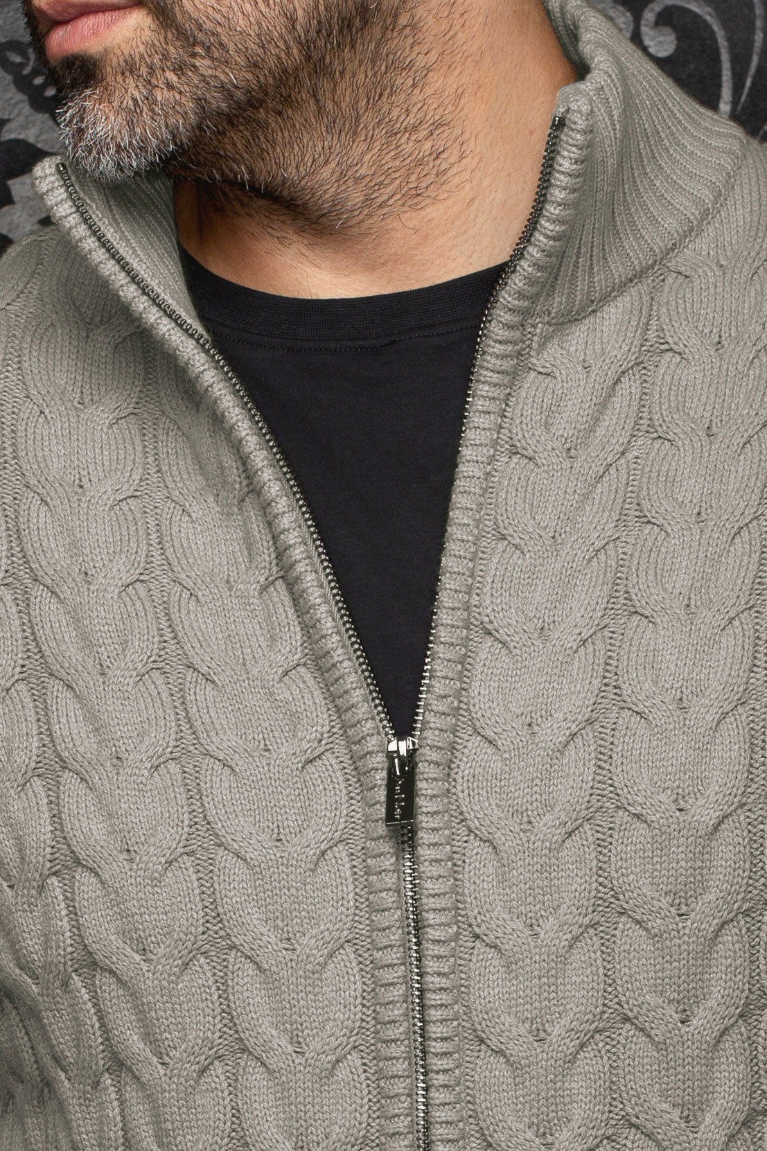 Gros plan de la veste en mérinos gris en tricot torsadé avec glissière et col côtelé pour homme par Au Noir