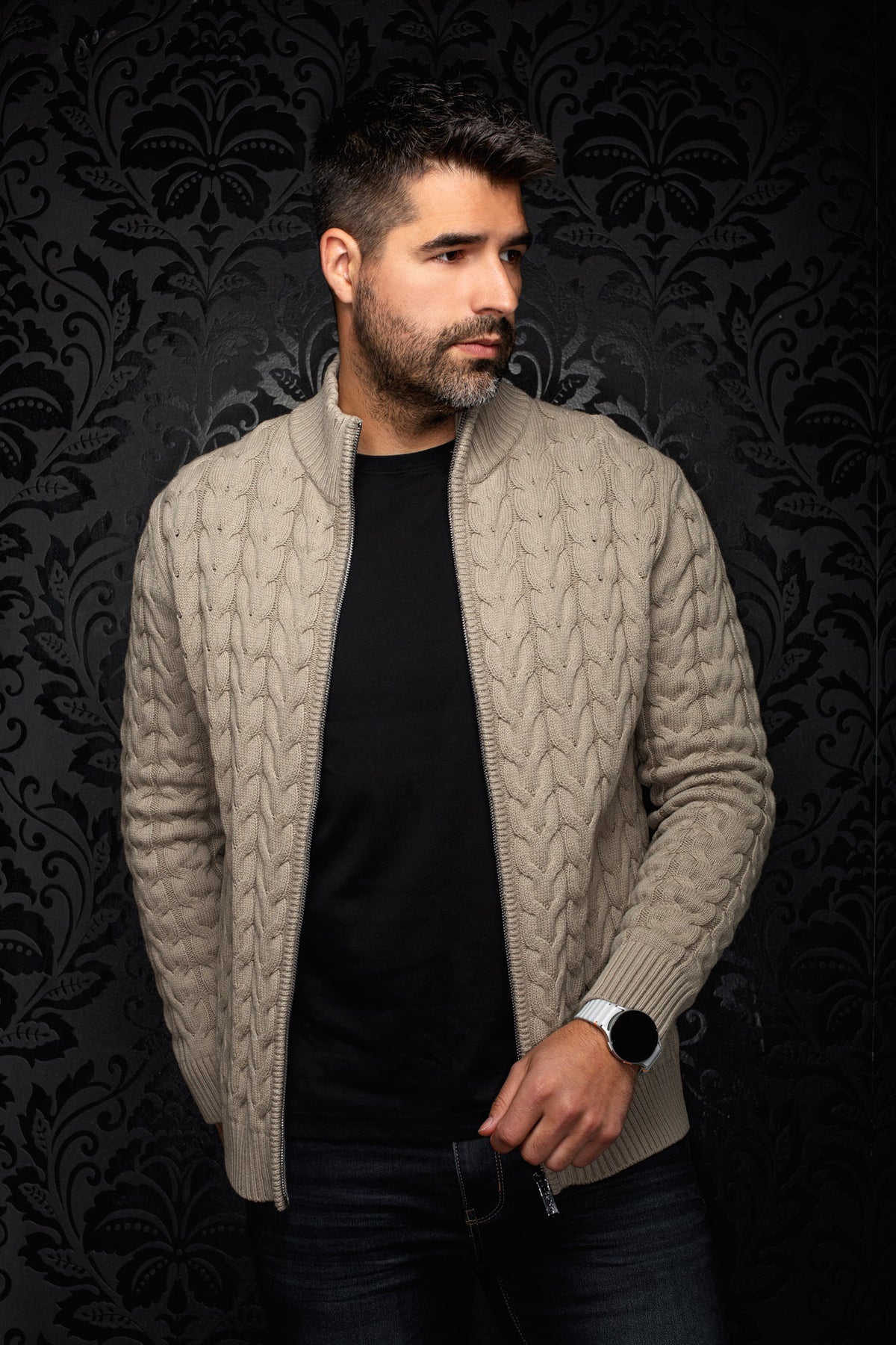 Sur mannequin de face, la veste en mérinos zippée en tricot torsadé beige portée ouverte pour homme par Au Noir