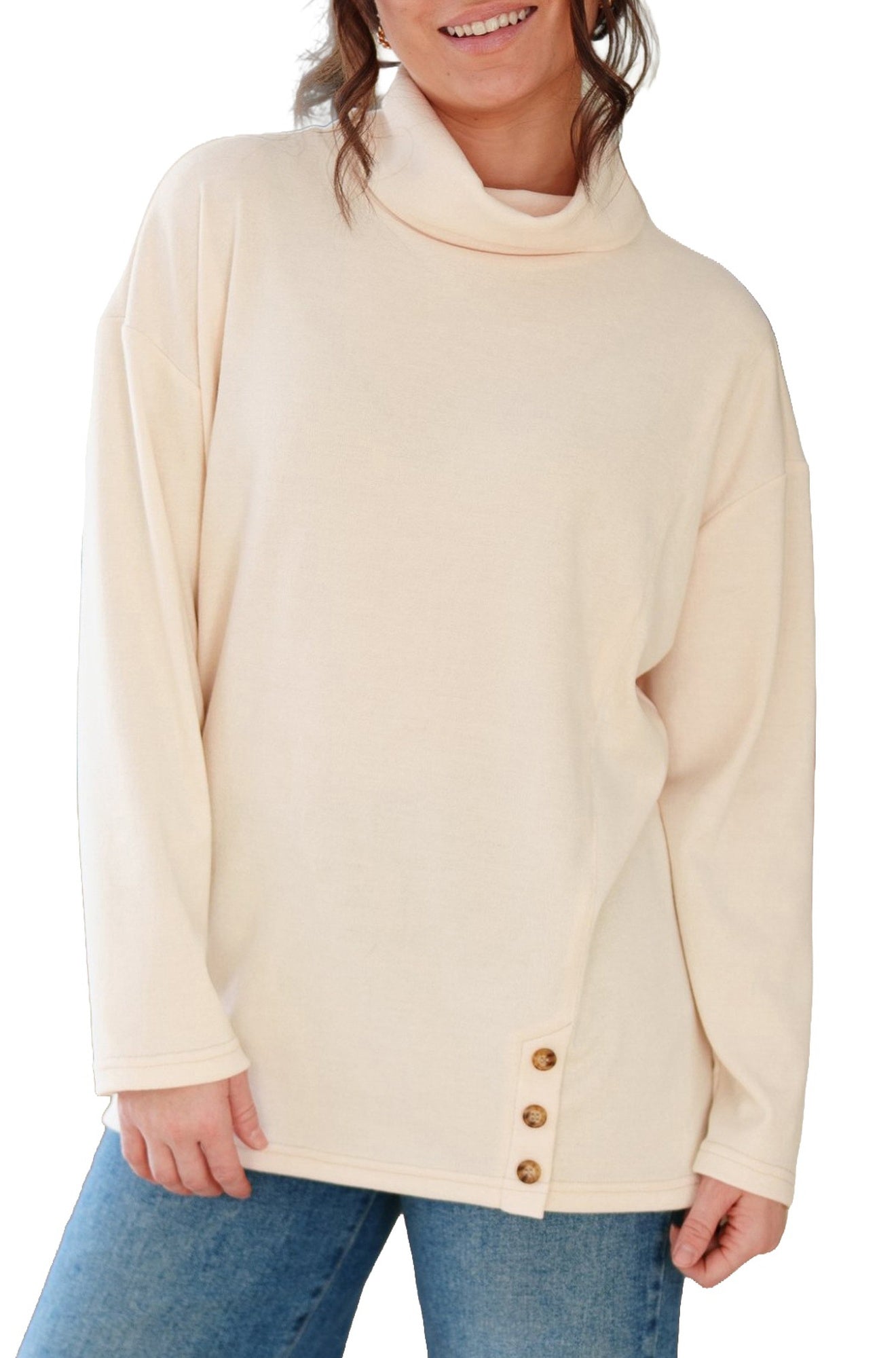 Women's angled front view of cream cowl neck tunic with long sleeves and side button hem by Rien ne se perd, tout se crée