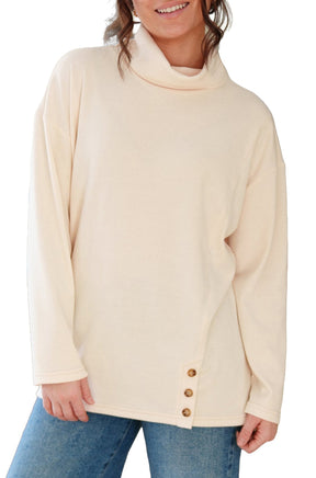 Women's angled front view of cream cowl neck tunic with long sleeves and side button hem by Rien ne se perd, tout se crée