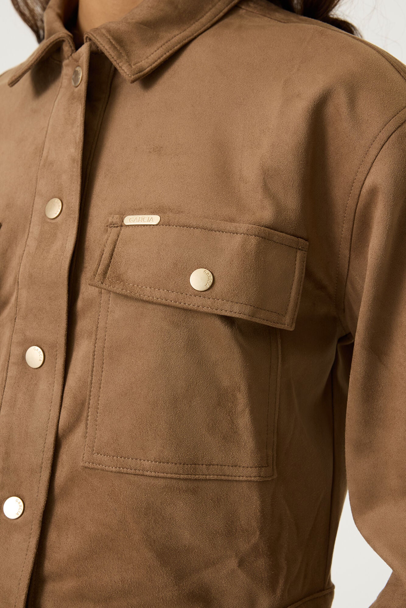 Détail de jacket brune tan aspect suède avec poche à rabat, boutons dorés et logo métal pour femme par Garcia