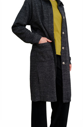 Women's side detail of charcoal ribbed long jacket showing patch pocket and button placket by Rien ne se perd, tout se crée