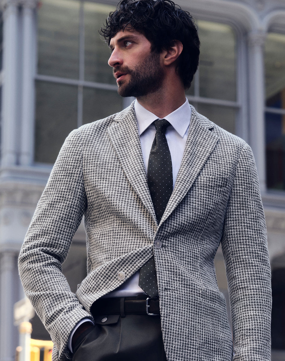 Veston BOSS gris à motif pied de poule avec chemise blanche et cravate noire, tenue d’affaires élégante pour homme.
