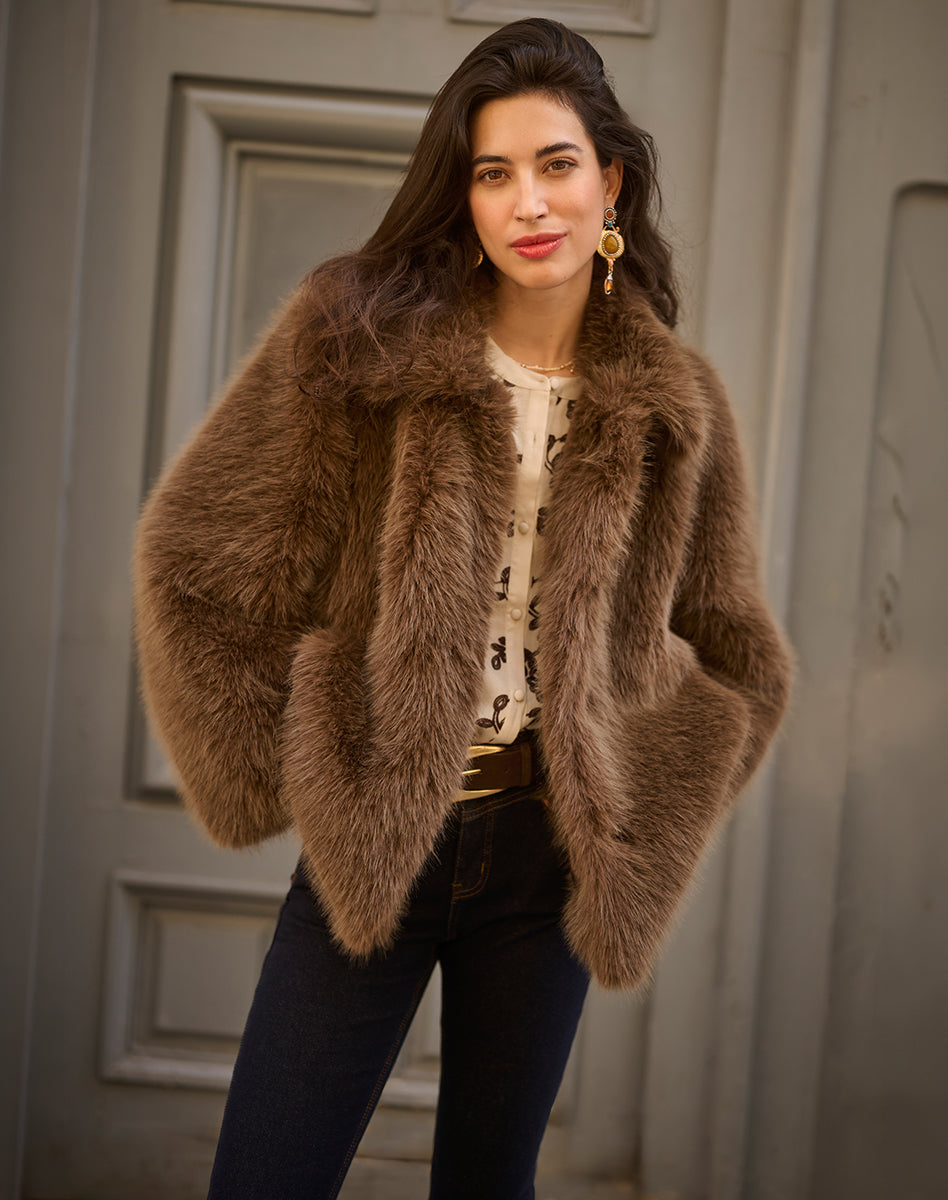 Brown faux fur Vest layered over a light blouse with dark jeans, warm women’s look for cooler weather.