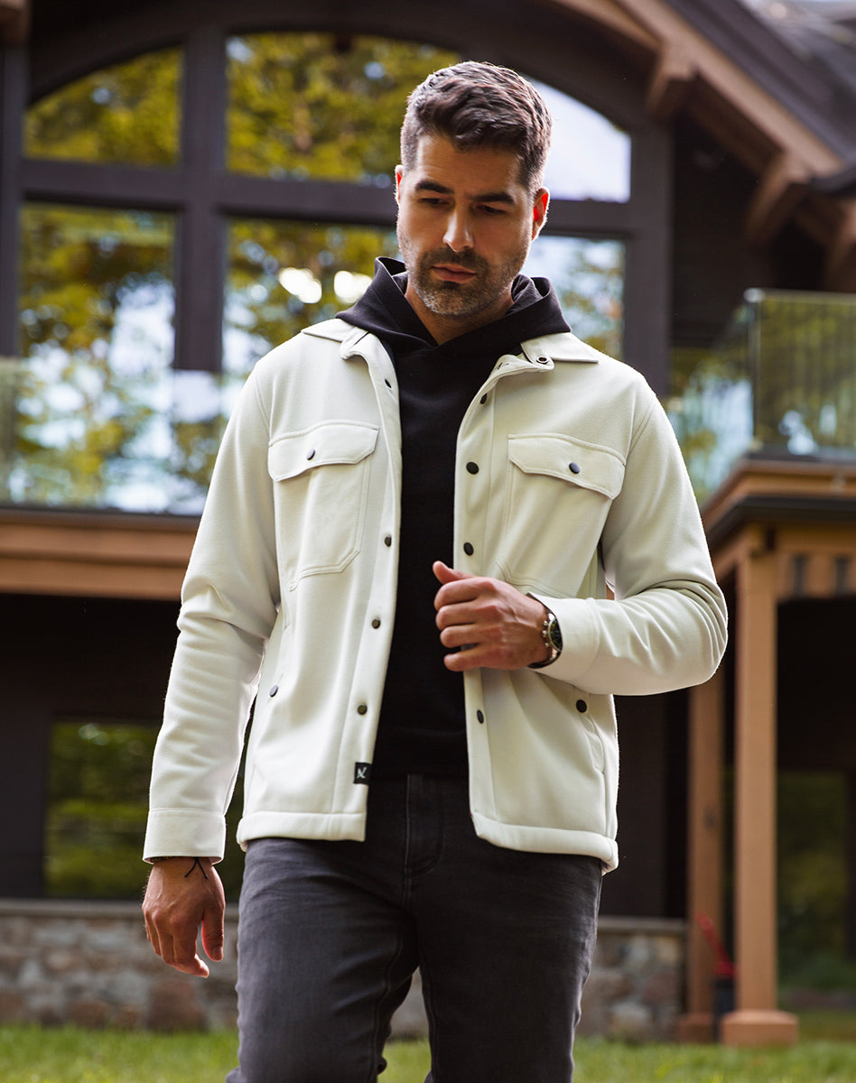 Off white overshirt with chest pockets layered over a black Hoodie, modern men’s outfit outdoors.